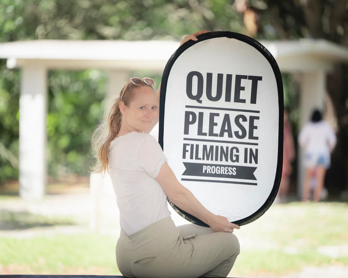 Quiet Please Filming in Progress sign held on video production set