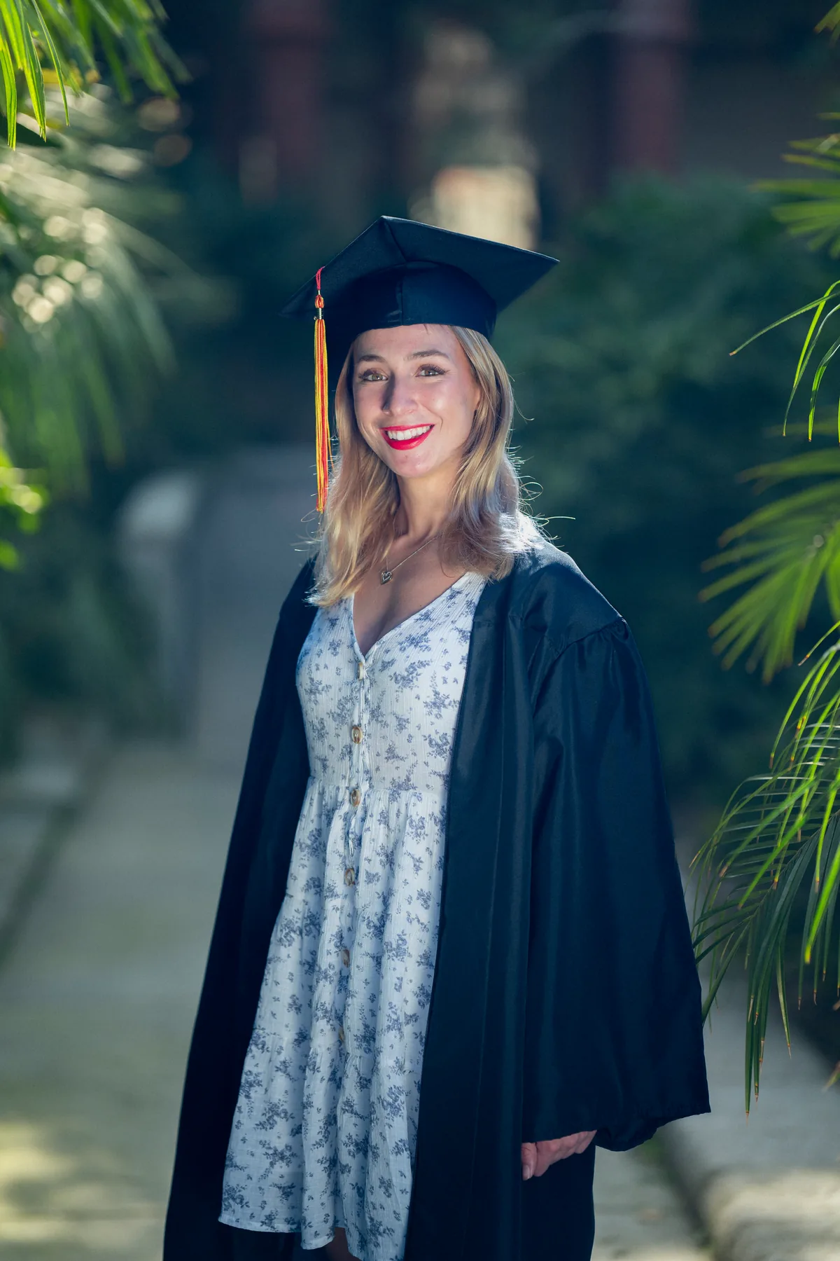 Flagler College graduate in cap and gown among the campus palms in St. Augustine — First Sight Films