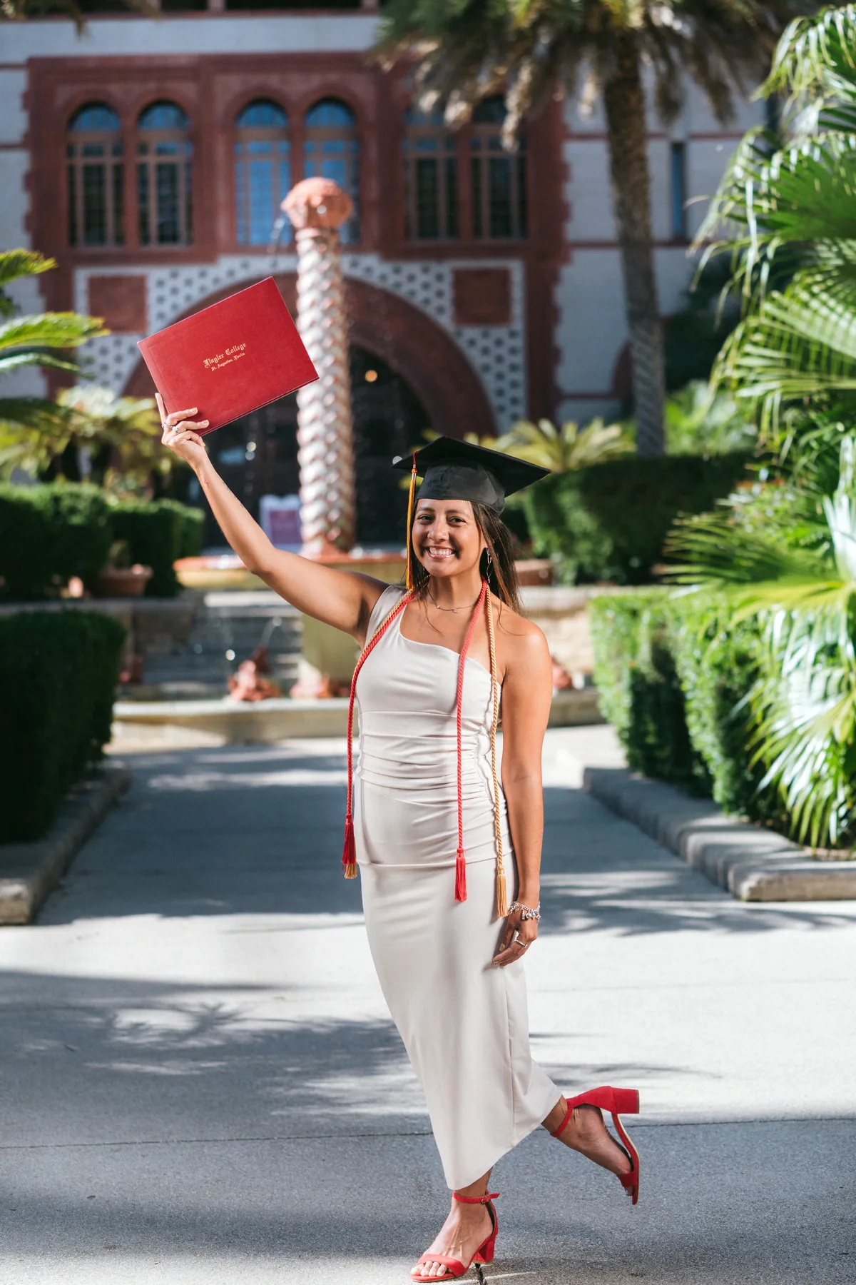 Flagler College graduate celebrating at a Spanish Renaissance archway on campus — First Sight Films