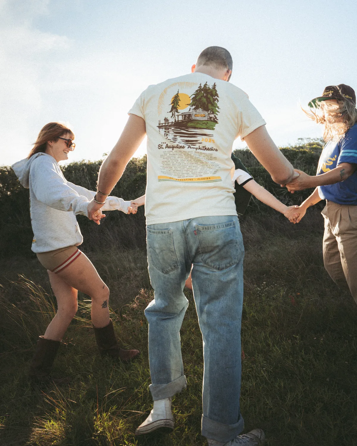 Group of models holding hands showing back of St Augustine Amphitheatre merch designs