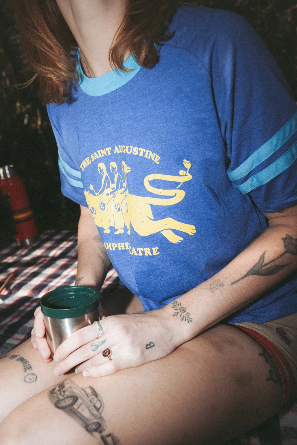 Candid lifestyle shot of model in vintage Amphitheatre ringer tee with coffee